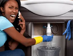 Emergency plumbing repair for a leaking sink drain under a bathroom vanity in Boston, MA