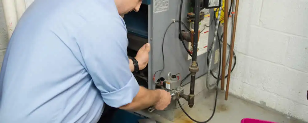 Furnace repair technician inspecting and servicing a home heating system in Boston, MA