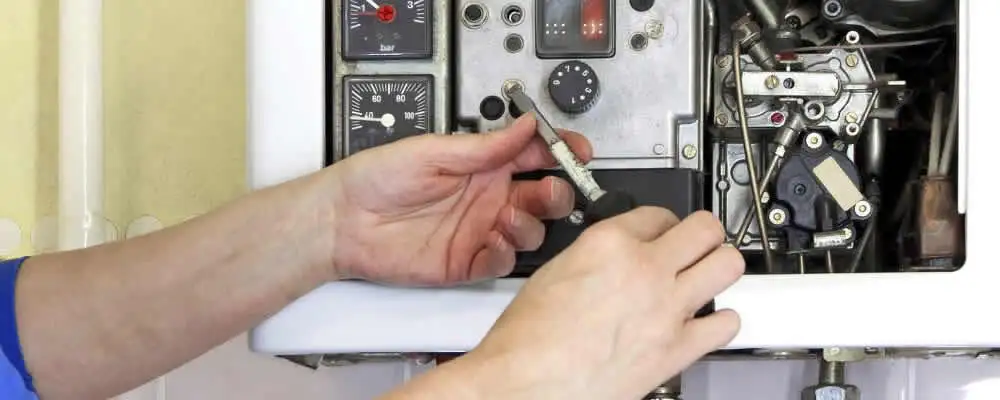 Heating repair technician adjusting boiler controls and components in Boston, MA