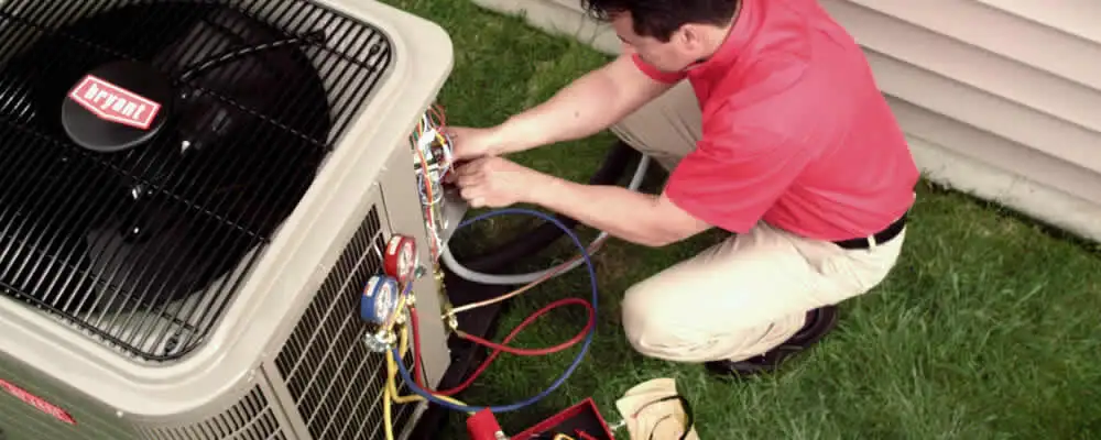 HVAC technician servicing an outdoor air conditioner unit in Boston, MA