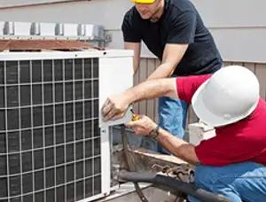 HVAC technicians repairing an outdoor AC unit on a rooftop in Boston, MA