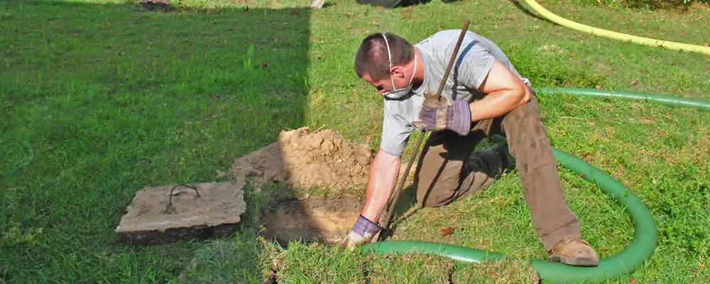 Septic pumping technician servicing a residential septic tank in Boston, MA